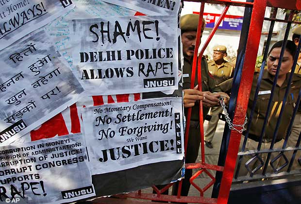 Indian police officers lock the gate of the police station during a protest condemning the gang rape of a 23-year-old student on a city bus late Sunday in New Delhi, India, Tuesday, Dec. 18, 2012. The Indian parliament Tuesday witnessed outrage over the issue even as the victim is battling for her life at a city hospital. (AP Photo/Tsering Topgyal)