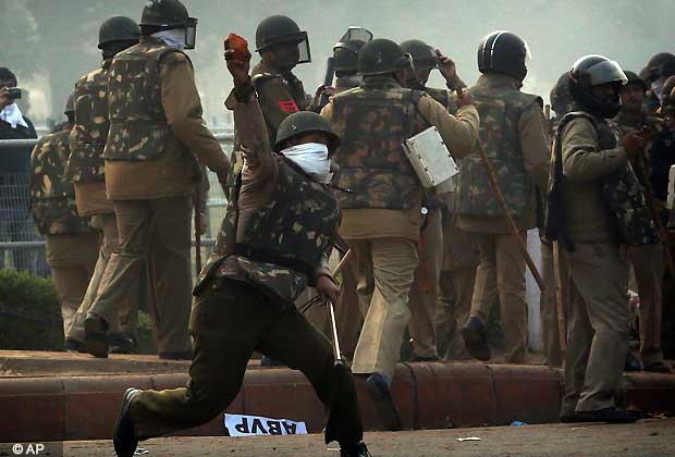 An Indian police officer throws back stones at protesters during a violent demonstration near the India Gate against a gang rape and brutal beating of a 23-year-old student on a bus last week, in New Delhi, India, Sunday, Dec. 23, 2012. The attack last Sunday has sparked days of protests across the country. (AP Photo/Saurabh Das)