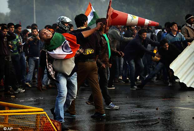 A protester throws a traffic cone at Indian police during a violent demonstration near the India Gate against the gang rape and brutal beating of a 23-year-old student on a bus last week, in New Delhi, India, Sunday, Dec. 23, 2012. The attack last Sunday has sparked days of protests across the country. (AP Photo/Kevin Frayer)
