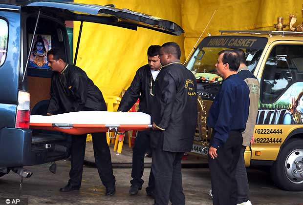 Workers from a Hindu Casket service unload the body of the young Indian woman who was gang-raped in New Delhi, to be embalmed on Saturday Dec. 29, 2012 in Singapore. (AP Photo/Wong Maye-E)