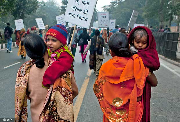 Indian women carry their children as they march during a protest to mourn the death of a gang rape victim in New Delhi, India, Wednesday, Jan. 2, 2013. (AP Photo/ Dar Yasin)