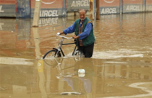 A Kashmiri man pushes his bicycle through a flooded highway near Pampore some 20 Kilometers (12.5 miles) south of Srinagar. Although flood waters were receding, residents in the main city of Srinagar were bracing for more trouble as the meteorological office has predicted more rain over the next few days.
