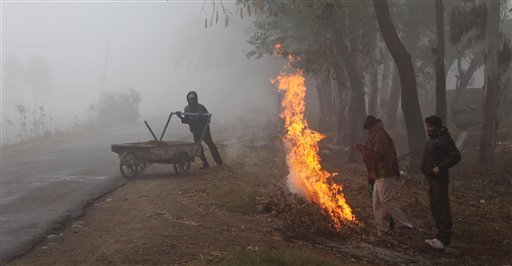 Indians warm themselves near a bonfire in Jammu