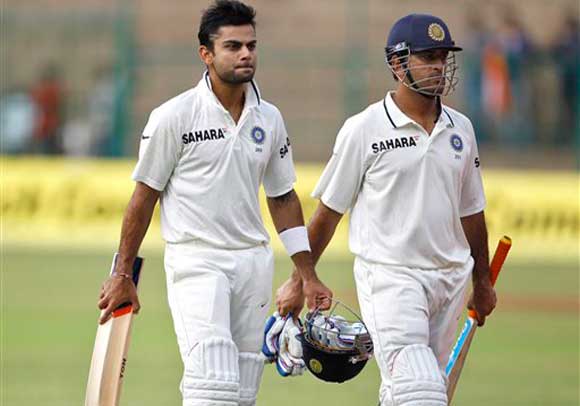 India's batsmen Virat Kohli, left, and captain Mahendra Singh Dhoni leave the ground at the end of the day two of their second cricket test match against New Zealand in Bangalore, India, Saturday, Sept. 1, 2012. India leads the series 1 0. (AP Photo/Aijaz Rahi)