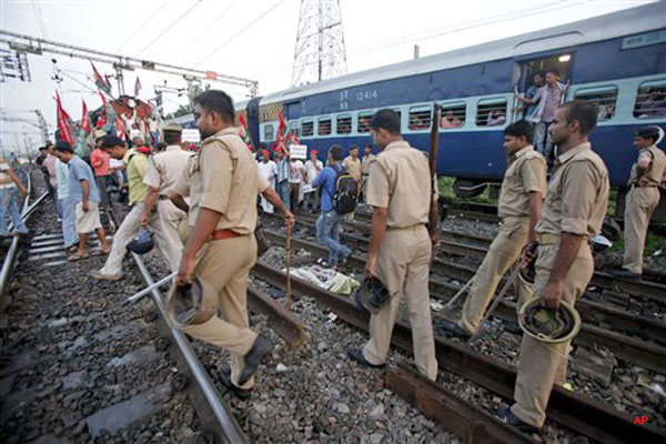 Indian policemen arrive as Samajwadi Party activists block trains during a protest along railway tracks in Allahabad, India, Thursday, Sept. 20, 2012. Angry opposition workers have disrupted train services as part of a daylong strike in India to protest rising diesel prices and the government's decision to open the country's huge retail market to foreign companies. (AP Photo/Rajesh Kumar Singh)