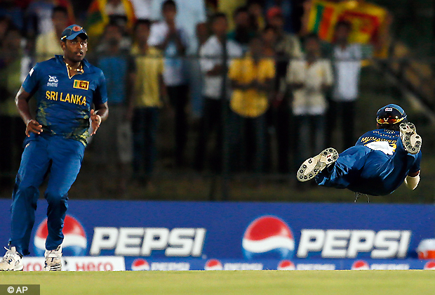 Sri Lanka's Thisara Perera, left, watches teammate Dilshan Munaweera, right, dive to hold a catch to dismiss South Africa's Richard Levi, unseen, during their ICC Twenty20 Cricket World Cup match in Hambantota, Sri Lanka, Saturday, Sept. 22, 2012. (AP Photo/Gemunu Amarasinghe)