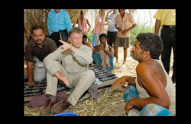 Microsoft co founder Bill Gates, left, speaks with a villager in Aulali, Khagaria district of Bihar state, before heading to Guleria, Wednesday, May 12, 2010, in India. Gates, whose philanthropic foundation has committed nearly $1 billion for health and development projects in India, traveled to Guleria, a remote village in eastern India to see the progress of the Indian government's campaign to eradicate polio. (AP Photo/Prashant Ravi)