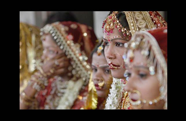 Indian brides look on at a mass marriage on Akshay Tritiya in Allahabad, India, Sunday, May 16, 2010. Akshay Tritiya, is an auspicious day for Hindu marriages and buying gold. (AP Photo/Rajesh Kumar Singh)