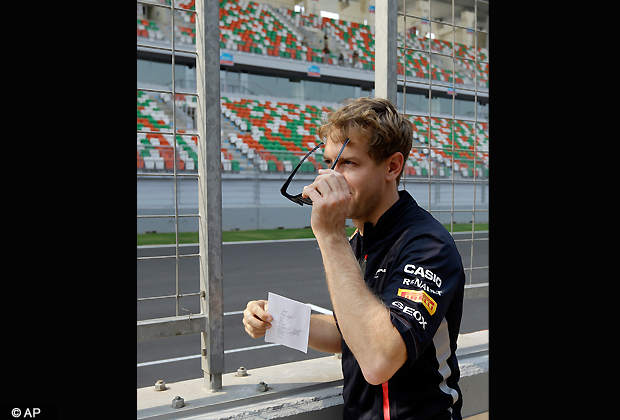 Red Bull driver Sebastian Vettel of Germany stands at the pit lane wall after walking the Buddh International Circuit ahead of the Indian Formula One Grand Prix in Noida, on the outskirts of New Delhi, India, Thursday, Oct. 25, 2012. (AP Photo/Mark Baker)