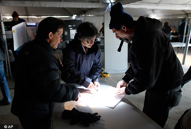 Election workers help a voter, right, finalize his affidavit ballot at a consolidated polling station for residents of the Rockaways on Election Day, Tuesday, Nov. 6, 2012, in the Queens borough of New York. Election Day turnout was heavy in several storm ravaged areas in New York and New Jersey. (AP Photo)