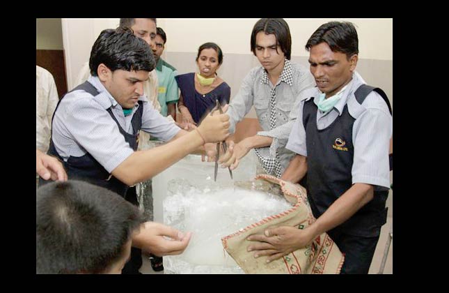 Hospital staff break ice to apply on heat stroke victims at a hospital in Ahmadabad, India, Friday, May 21, 2010. Gujarat state recorded a high of 48.5 degree Celsius (119.3 Fahrenheit) for the first time in the history of the state, according to officials of the India Meteorological Department. (AP Photo/Ajit Solanki)
