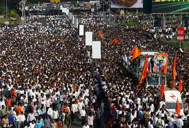 Mourners walk beside a truck carrying the body of Shiv Sena leader Bal Thackeray during his funeral in Mumbai, Nov. 18, 2012. Thackeray died on Saturday after an illness of several weeks. He was 86. (AP Photo)
