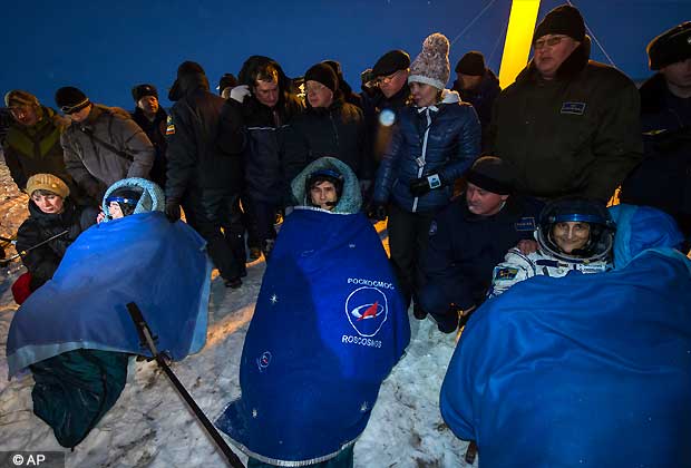 Expedition 33 Commander Sunita Williams of NASA, right, and Flight Engineers Yuri Malenchenko of ROSCOSMOS, and Akihiko Hoshide of JAXA, left, sit in chairs outside the Soyuz Capsule just minutes after they landed in a remote area outside the town of Arkalyk, Kazakhstan, on Monday, Nov. 19, 2012. (AP Photo)