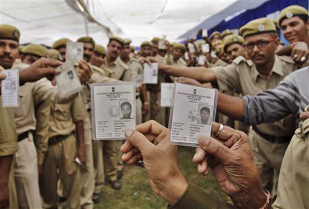 Indian policemen show their election identification cards to photographer as they stand in a queue to receive their postal ballot as part of a special arrangement made by the election commission for the upcoming assembly elections, in Ahmadabad, India, Sunday, Dec. 9, 2012. The election commission has made special arrangements for voluntary voting through postal ballot for the police personnel who are deployed for election duty. Elections will be held in Gujarat state in two phases on Dec. 13 and 17 and counting of votes on Dec. 20.