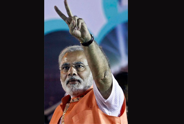 In this Sunday, Dec. 9, 2012 photo, Gujarat state chief minister Narendra Modi flashes a victory sign to crowd during an election campaign rally in Ahmadabad, India. Elections will be held in Gujarat state in two phases on Dec. 13 and 17 and counting of votes on Dec. 20. (AP Photo)