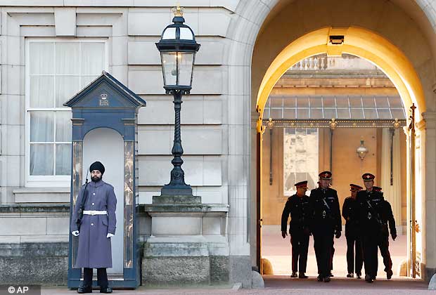 Jatinderpal Singh Bhullar, 25, a Sikh soldier with the Scots Guardsmen, performs guarding duties outside Buckingham Palace in central London, Tuesday, Dec. 11, 2012. becoming the first guardsman to parade wearing a turban instead of the famous bearskin. Other Sikhs have taken part in guarding the queen's palace in the past but they wore traditional bearskin hats, rather than turbans. (AP Photo/Lefteris Pitarakis)