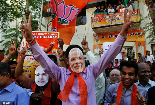 Indian supporters of Bharatiya Janata Party (BJP) wear masks of Gujarat chief minister Narendra Modi as they celebrate to early reports that their party is leading in the Gujarat assembly elections in Ahmadabad, India, Thursday, Dec. 20, 2012. The votes are currently being counted with the final results expected later in the day. (AP Photo/Ajit Solanki)