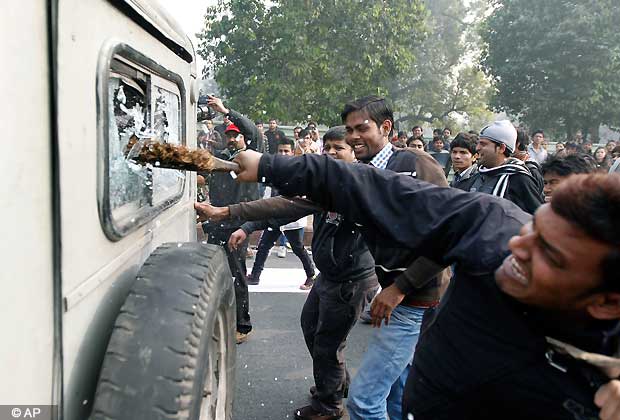 Indian protestors damage a government vehicle during a violent demonstration near the India Gate monument against a gang rape and brutal beating of a 23 year old student on a bus last week, in New Delhi, India, Sunday, Dec. 23, 2012. The attack last Sunday has sparked days of protests across the country. (AP Photo/ Mustafa Quraishi)