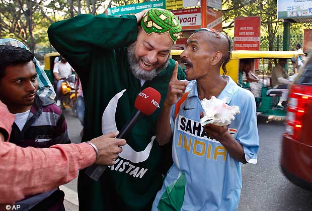 Pakistan cricket fan, Mohammad Bashir, second left, of Chicago, reacts as Indian fan Sudhir Kumar, right, shouts slogans in front of the Chinnaswamy Stadium, the venue of first Twenty20 cricket match between India and Pakistan, in Bangalore, India. (AP Photo/Aijaz Rahi)