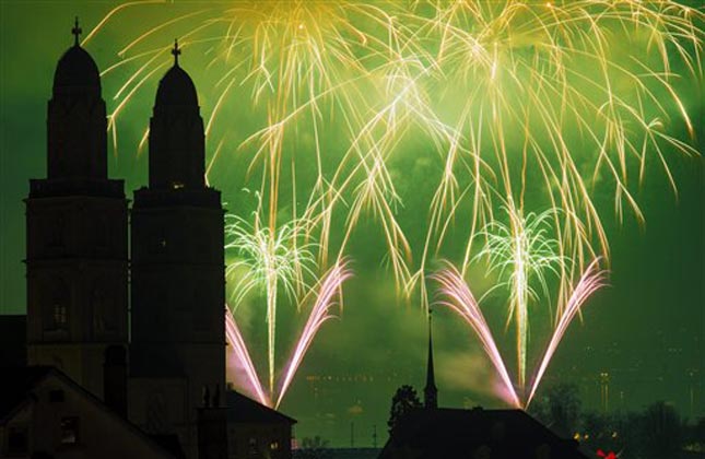 In this picture made available Tuesday, Jan. 1, 2013, fireworks illuminate the sky next to the Grossmuenster cathedral during the New Year's Eve festivities in Zurich, Switzerland, Dec. 31, 2012. (AP Photo/Keystone, Walter Bieri)