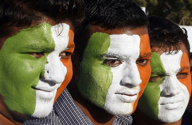 Indian cricket fans, faces painted with the colors of the Indian flag, wait to enter the Sardar Patel Stadium, venue of the second Twenty20 cricket match between India and Pakistan, in Ahmadabad, India, Friday, Dec. 28, 2012. India and Pakistan are playing their first bilateral series since November 2007, comprising two Twenty20 matches and three one day internationals. (AP Photo/Ajit Solanki)