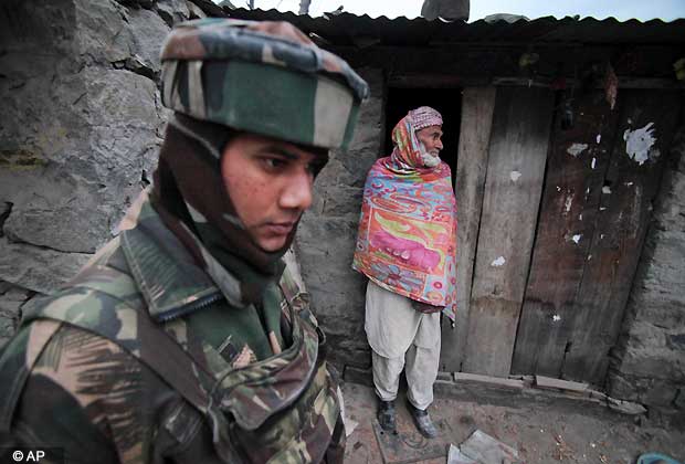 An Indian army soldier patrols past the home of a local resident near the line of control, the line that divides Kashmir between India and Pakistan, after reported ceasefire violation, in Mendhar, Poonch district, about 210 kilometers (131 miles) from Jammu, India, Wednesday, Jan. 9, 2013. (AP Photo/Channi Anand)