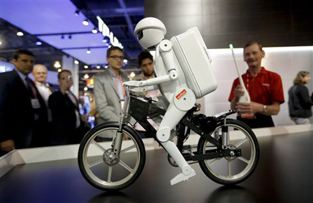 Murata Boy, a bicycle riding robot, rides a bike at the Murata booth at the at the International Consumer Electronics Show in Las Vegas, Tuesday, Jan. 8, 2013. (AP Photo/Jae C. Hong)