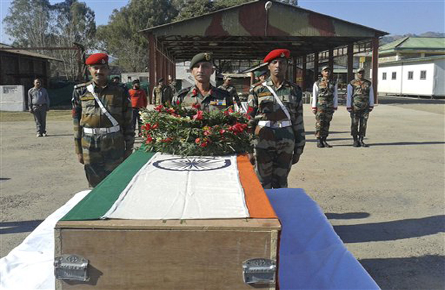 Indian army soldiers offer prayers near the body of a colleague who was allegedly killed by Pakistani soldiers, in Rajouri, India, Wednesday, Jan. 9, 2013. India summoned Pakistan's top diplomat in New Delhi on Wednesday to formally complain about an attack on an Indian army patrol in the disputed Himalayan region of Kashmir that killed two soldiers and left their bodies mutilated. (AP Photo)