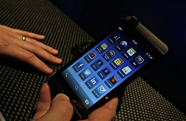 A man holds the new touchscreen BlackBerry Z10 smartphone, during a launch event for the new phone in London, Wednesday, Jan. 30, 2013.(AP Photo/Lefteris Pitarakis)