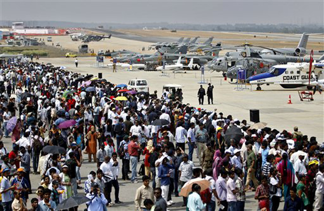 Visitors crowd at the static display area for aircraft on the third day of the Aero India 2013 at Yelahanka air base in Bangalore, India, Friday, Feb. 8, 2013. More than 600 aviation companies along with delegations from 78 countries are participating in the five day event that started Wednesday. (AP Photo/Aijaz Rahi)