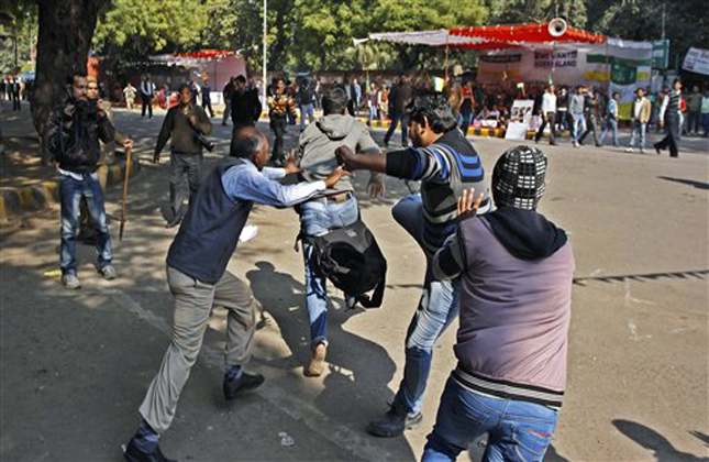 Hindu right winged Bajrang Dal activists attack a man protesting the execution of a Kashmiri Mohammed Afzal Guru, in New Delhi, India, Saturday, Feb. 9, 2013. Guru, convicted in a 2001 attack on India's Parliament that left 14 people dead, was hanged Saturday after a final mercy plea was rejected, a senior Indian Home Ministry official said. About 30 Kashmiri students and anti death penalty activists clashed with Indian police and right wing Hindu groups in New Delhi. (AP Photo/Tsering Topgyal)