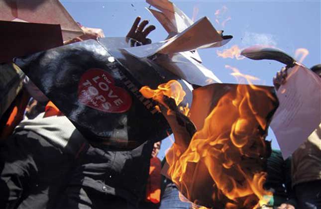 A small group of Hindu nationalist Ram Sena activists burn greeting cards during a protest against Valentine's Day celebrations in Jammu, India, Tuesday, Feb. 12, 2013. Hard line Hindu groups routinely protest against the perceived invasion of western culture into India. (AP Photo/Channi Anand)