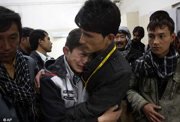 A Pakistani man comforts another mourning for a family member who died in a bomb blast, at local hospital in Quetta, Pakistan on Saturday, Feb. 16, 2013. Senior police officer Wazir Khan Nasir said the bomb went off in a Shiite Muslim dominated residential suburb of the city of Quetta. Residents rushed the victims to three different hospitals.
