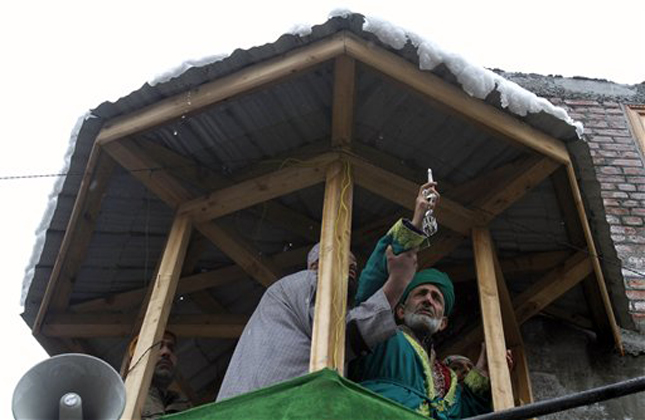 A Kashmiri head priest, right, displays a relic of Syed Abdul Qadir Jilani, at his shrine in Srinagar, India, Saturday, Feb. 23, 2013. Thousands of devotees thronged to the Syed Abdul Qadir Jilani's shrine which houses the relic of the saint, during an 11 day festival to mark the saint's Urs, or yearly commemoration. (AP Photo/Mukhtar Khan)