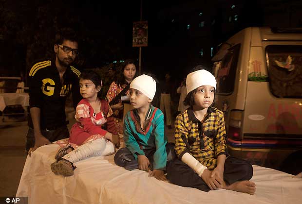 Pakistani children, who were slightly injured in a bomb blast, are brought to a hospital in Karachi, Pakistan, Sunday, March 3, 2013. Pakistani officials say a bomb blast has killed dozens of people in a neighborhood dominated by Shiite Muslims in the southern city of Karachi.