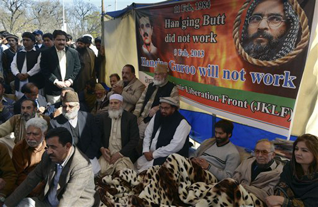 Pakistani religious and Kashmiri leaders join the chairman of the Jammu Kashmir Liberation Front, Yasin Malik, third from right, who is on a hunger strike to protest the hanging of a Kashmiri man, Mohammed Afzal Guru, whose portraits are seen on banner, in Islamabad, Pakistan, Sunday, Feb. 10, 2013. A senior Indian Home Ministry official said Guru, convicted in a 2001 attack on India's Parliament that left 14 people dead, was hanged Saturday after a final mercy plea was rejected. (AP Photo/A.H. Chaudary)