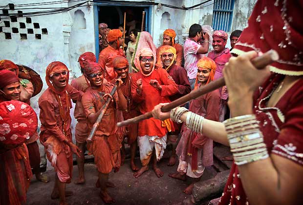 An Indian woman from the village of Barsana hits villagers from Nandgaon with a wooden stick during the Lathmar Holy festival the legendary hometown of Radha, consort of Hindu God Krishna, in Barsana, 115 kilometers (71 miles) from New Delhi, India, Thursday, March 21, 2013.