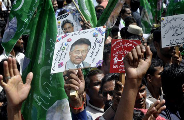 Supporters of Former Pakistani President Pervez Musharraf, hold placards showing him, upon his arrival to Karachi airport, Pakistan, Sunday, March 24, 2013. Former Pakistani President Pervez Musharraf ended more than four years in self exile Sunday with a flight to his homeland, seeking a possible political comeback in defiance of judicial probes and death threats from Taliban militants. (AP Photo/S.I. Ali)