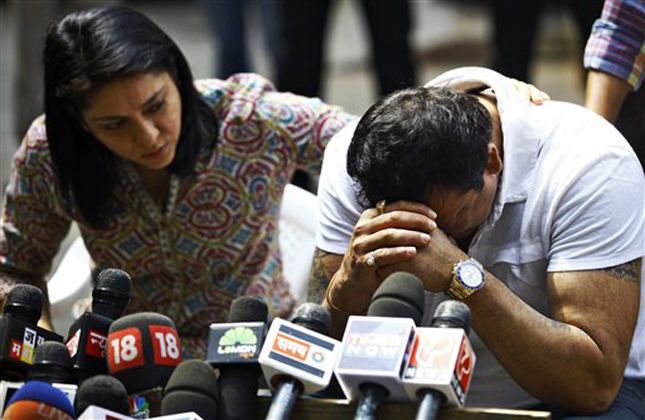 Indian Bollywood actor Sanjay Dutt, right, breaks down as his sister Priya Dutt tries to console him during a press conference at his residence in Mumbai, India, Thursday, March 28, 2013. Dutt says he has not sought pardon for a 1993 weapons conviction and will serve his prison sentence as ordered by India's Supreme Court. Dutt broke his silence a week after the court sentenced him to five years in prison for illegal possession of weapons supplied by Mumbai crime bosses linked to a 1993 terror attack that killed 257 people.(AP Photo/Rafiq Maqbool)