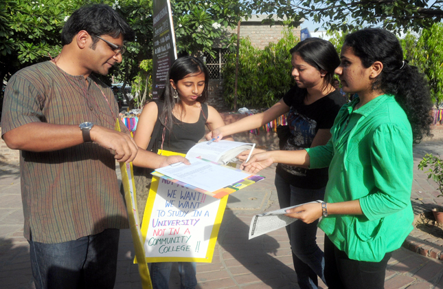 Delhi University students during a signature campaign against the four years degree courses in Delhi Unniversity at Dilli Hat in New Delhi on April 7, 2013. (Photo IANS)