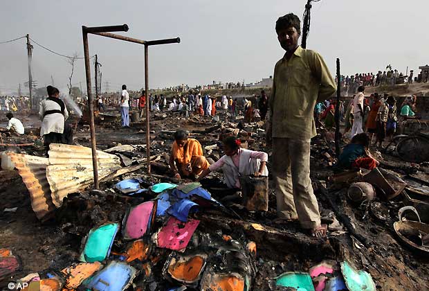 Residents salvage their belongings after a fire gutted their shanty town in New Delhi, India , Friday, April 12, 2013. A fire swept through a sprawling slum on the outskirts of India's capital on Friday, killing two children and injuring at least six other people, an official said.