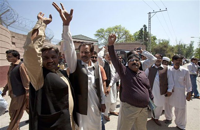 Supporters of Pakistan's former President and military ruler Pervez Musharraf chant slogans against the court decision outside his house in Islamabad on Thursday, April 18, 2013. Musharraf and his security team pushed past policemen and sped away from a court in the country's capital on Thursday after his bail was revoked in a case in which he is accused of treason. (AP Photo/B.K. Bangash)