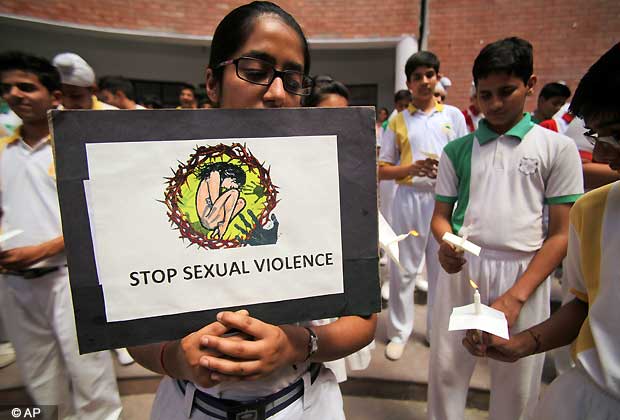 A student holds placard during a candle light vigil for the speedy recovery of a 5 year old girl who was raped and tortured in Delhi, at Heritage School in Jammu, India, Saturday, April 20, 2013. Officials say the 5 year old girl is in serious condition after being raped and tortured by a man who held her in a locked room in India's capital for two days.