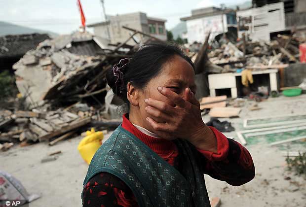 A village woman reacts after her house was damaged by an earthquake in Lushan county, Ya'an, southwest China's Sichuan province on Saturday, April 20, 2013. The powerful earthquake struck the steep hills of China's southwestern Sichuan province Saturday, nearly five years after a devastating quake wreaked widespread damage across the region.