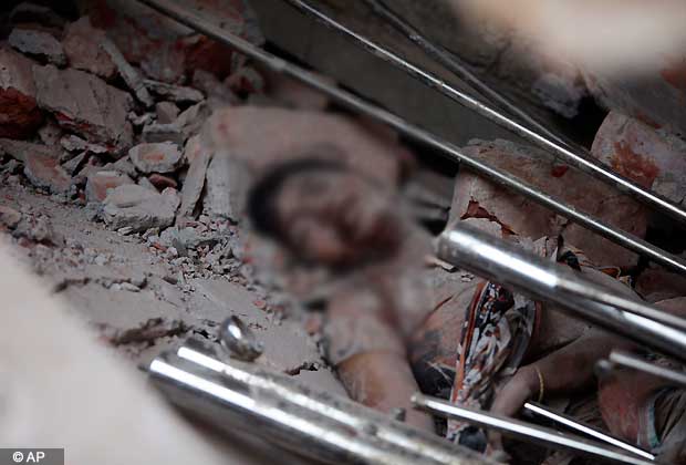 A victim's body lies amid rubble after an eight story building housing several garment factories collapsed in Savar, near Dhaka, Bangladesh, Wednesday, April 24, 2013. Dozens were killed and many more are feared trapped in the rubble.