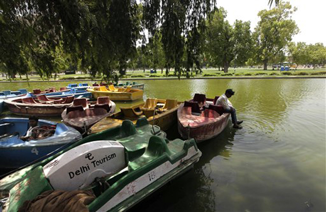 Indian boatmen sit idle at the deserted India Gate boat club after people opted to stay indoors following the rise in temperature in New Delhi, India, Monday, May 20, 2013. Severe heat conditions are prevailing across northern India with temperatures soaring past 45 degrees Celsius (113 Fahrenheit) at several places. (AP Photo /Manish Swarup)