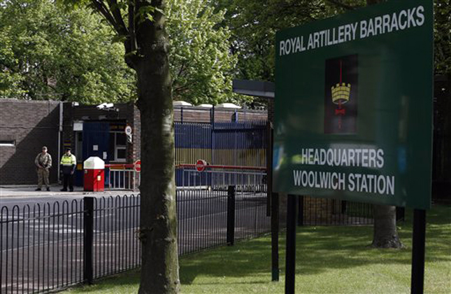 A armed soldier stands guard at the gate of Royal Artillery Barracks near the scene of a terror attack in Woolwich, southeast London, Thursday, May 23, 2013. Police remained at the scene throughout the night after a brutal attack in a London street Wednesday, which left one member of the armed forces dead and two injured, and the two attackers were also hospitalised. The British government Cabinet's emergency committee immediately called a meeting and Prime Minister David Cameron's office said security was stepped up at barracks across London. (AP Photo/Sang Tan)