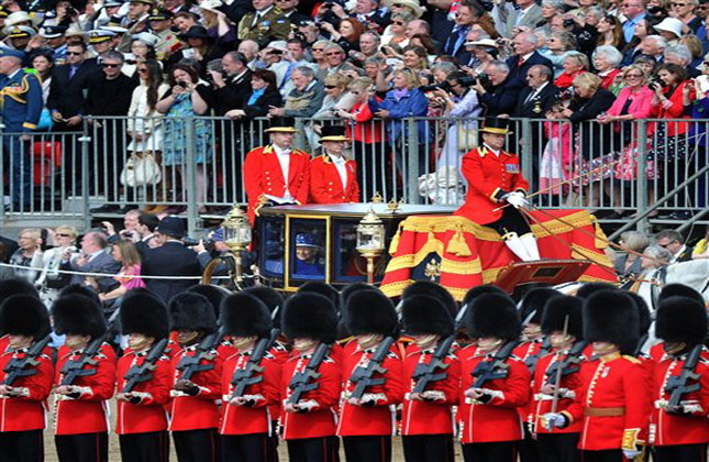 Britain's Queen Elizabeth II, centre in carriage, arrives at Horse Guards Parade, to attend the Trooping the Colour parade, in London, Saturday, June 15, 2013. Queen Elizabeth II is celebrating her birthday with traditional pomp and circumstance but without her husband by her side. More than 1,000 soldiers, horses and musicians are taking part in the parade known as Trooping the Color, an annual ceremony. (AP Photo/Anthony Devlin, PA) UNITED KINGDOM OUT