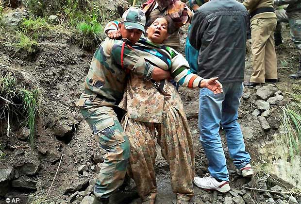 An Indian army personnel carries a stranded woman pilgrim to a safer area in Chamoli district, in the northern Indian state of Uttarakhand, India, Tuesday, June 18, 2013. Floods triggered by torrential rains have killed many people in northern India. More than 1,000 pilgrims are stranded at various locations due to floods and landslides. according to reports.