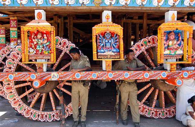 Indian policemen stand guard near a chariot meant for the annual Rath Yatra or Chariot procession of Lord Jagannath in Puri, 60 kilometers (37 miles) from the eastern Indian city of Bhubaneswar, India, Tuesday, July 9, 2013. The three idols of Hindu God Jagannath, his brother Balabhadra and sister Subhadra are taken out in a grand procession in specially made chariots called raths, which are pulled by thousands of devotees during the Rath Yatra or the chariot festival scheduled on July 10. AP Photo